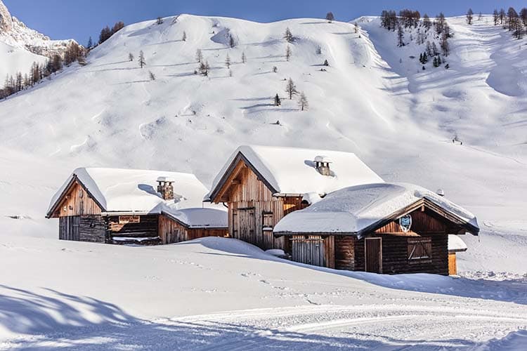 Traditional Austrian chalets beneath snow-covered Alpine mountains